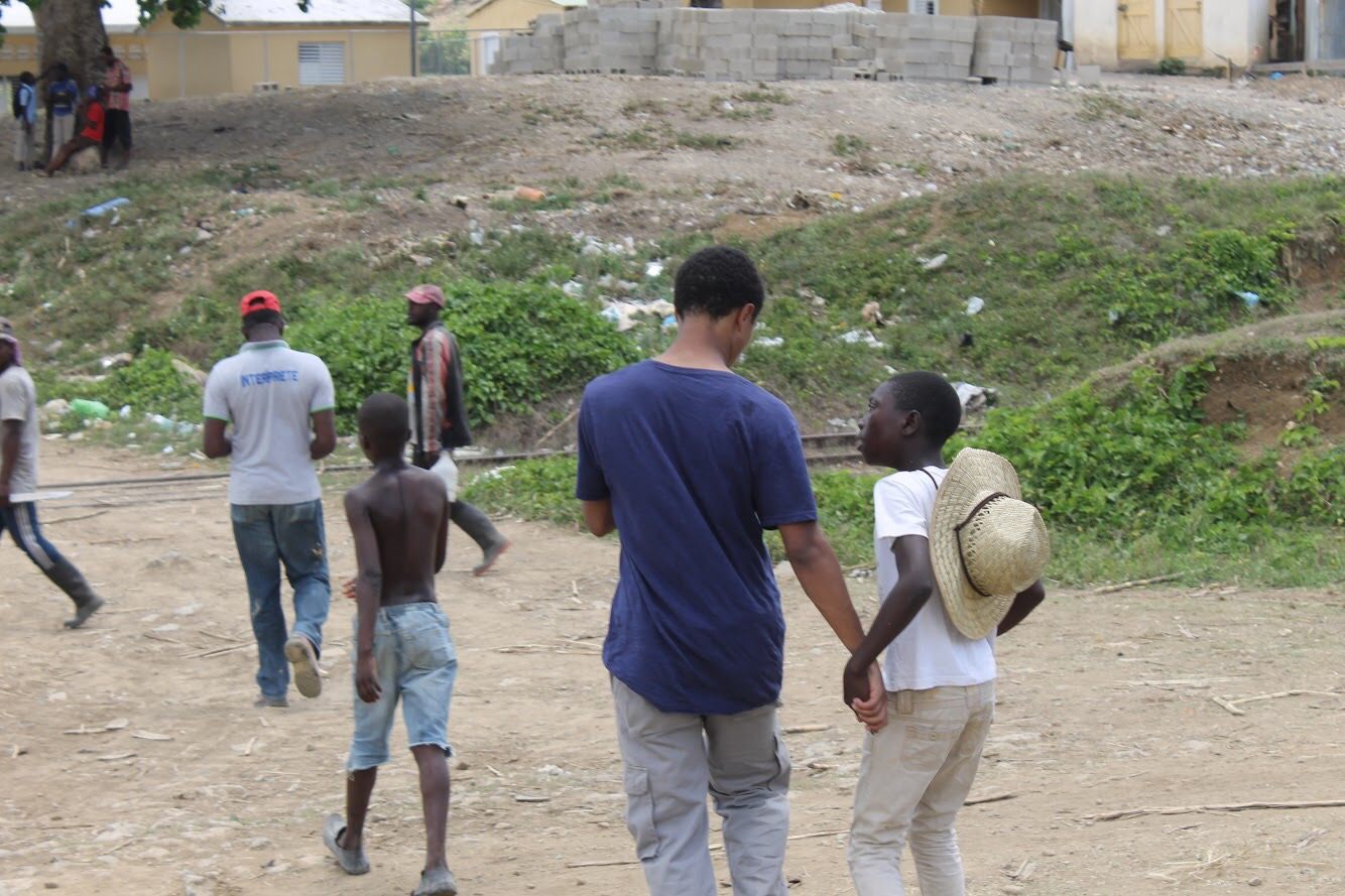 Elijah walking hand in hand with a child in the Dominican Republic
